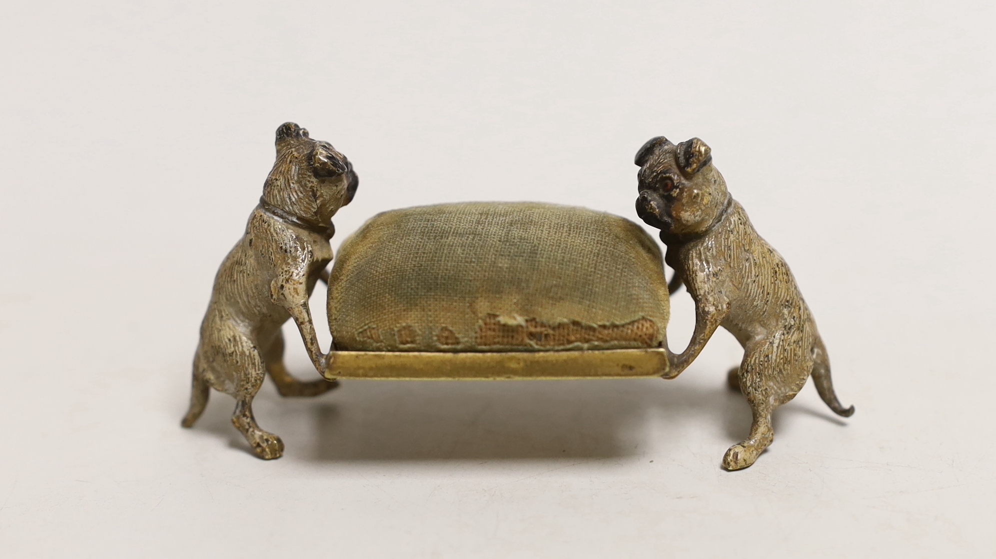 An early 20th century Austrian cold painted bronze ‘pug dogs’ pin cushion, 9cm long